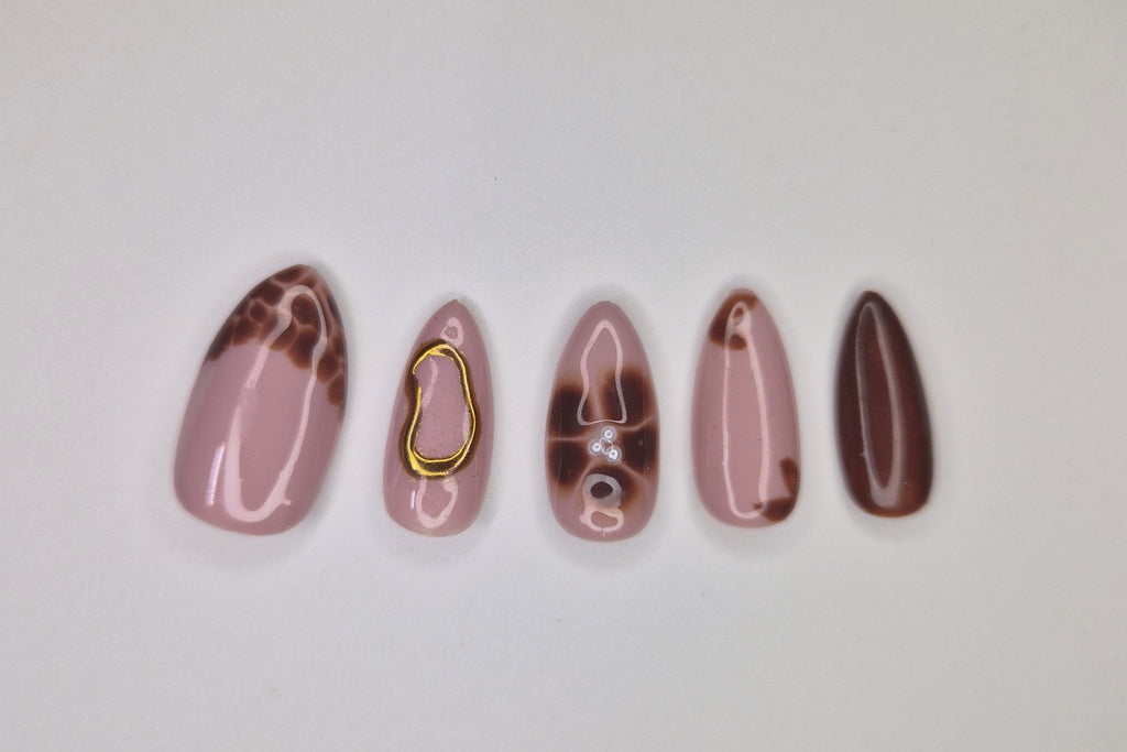 Set of five marbled nail art designs on a white background