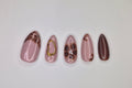 Set of five marbled nail art designs on a white background