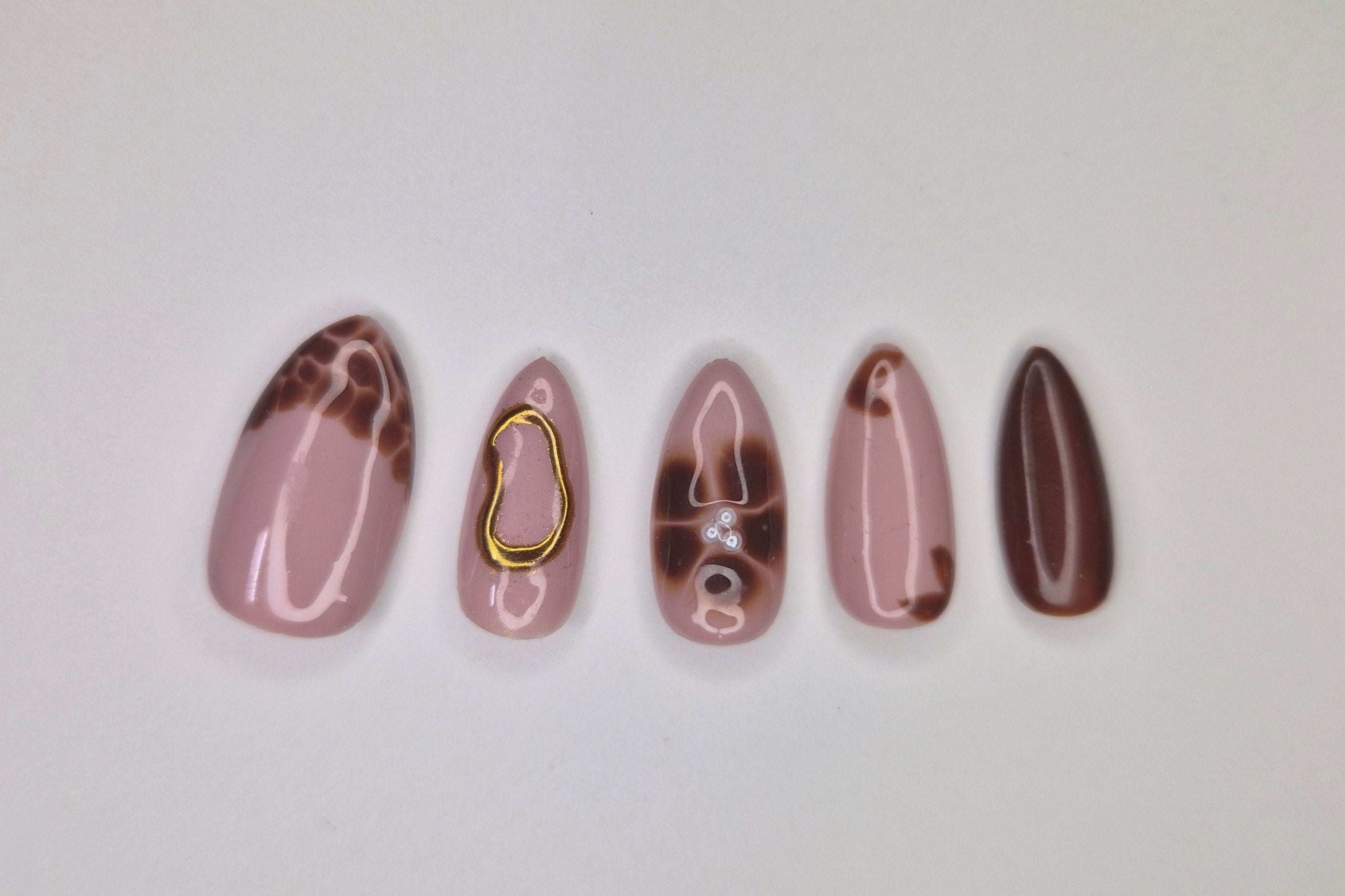 Set of five marbled nail art designs on a white background